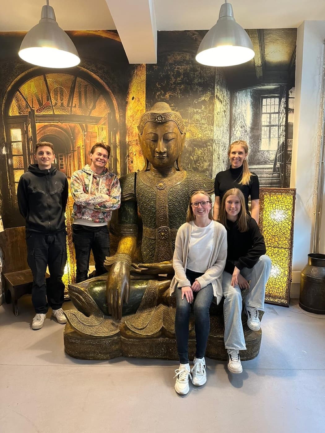The team in front of a Buddha statue